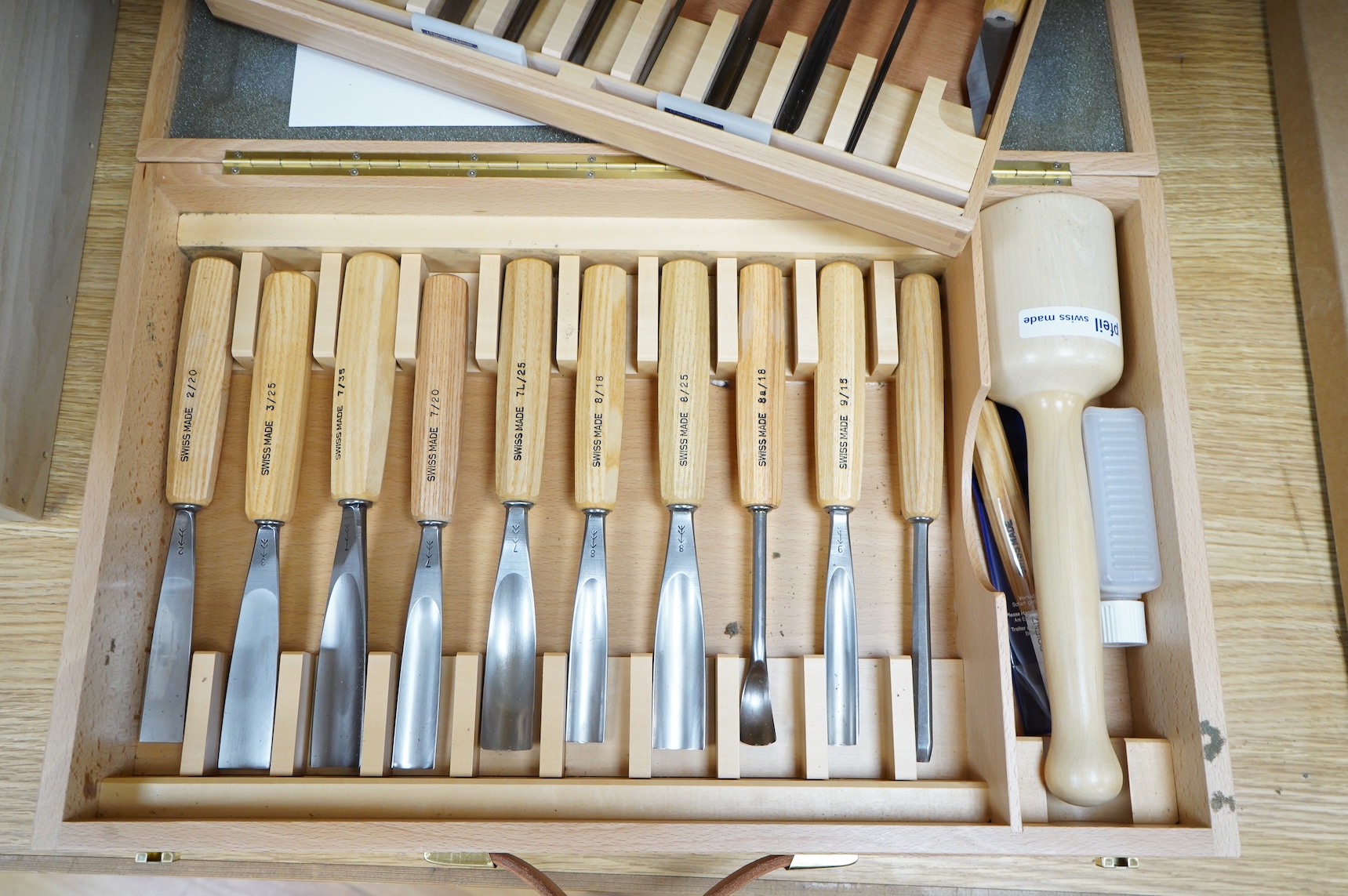 A Swiss made Pfeil 25-piece wood carving set, comprising; carving chisels, a mallet, sharpening stones, etc. contained within a fitted beech case, 530 x 330 x 95mm